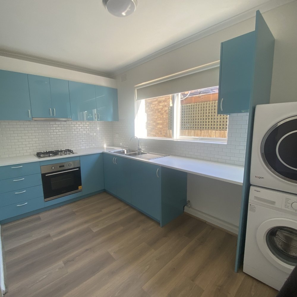 A newly renovated kitchen with modern appliances, sleek countertops, fresh cabinets, and bright lighting