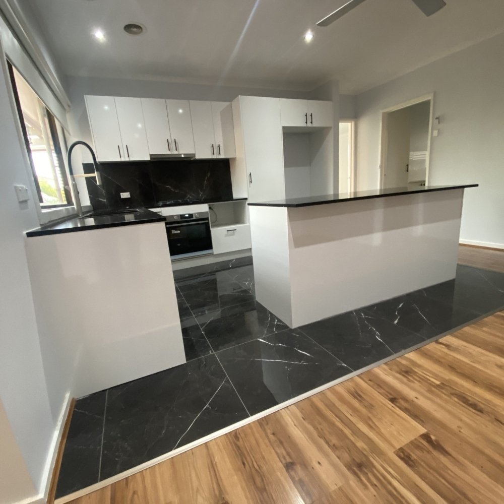 A fully renovated kitchen featuring modern cabinets