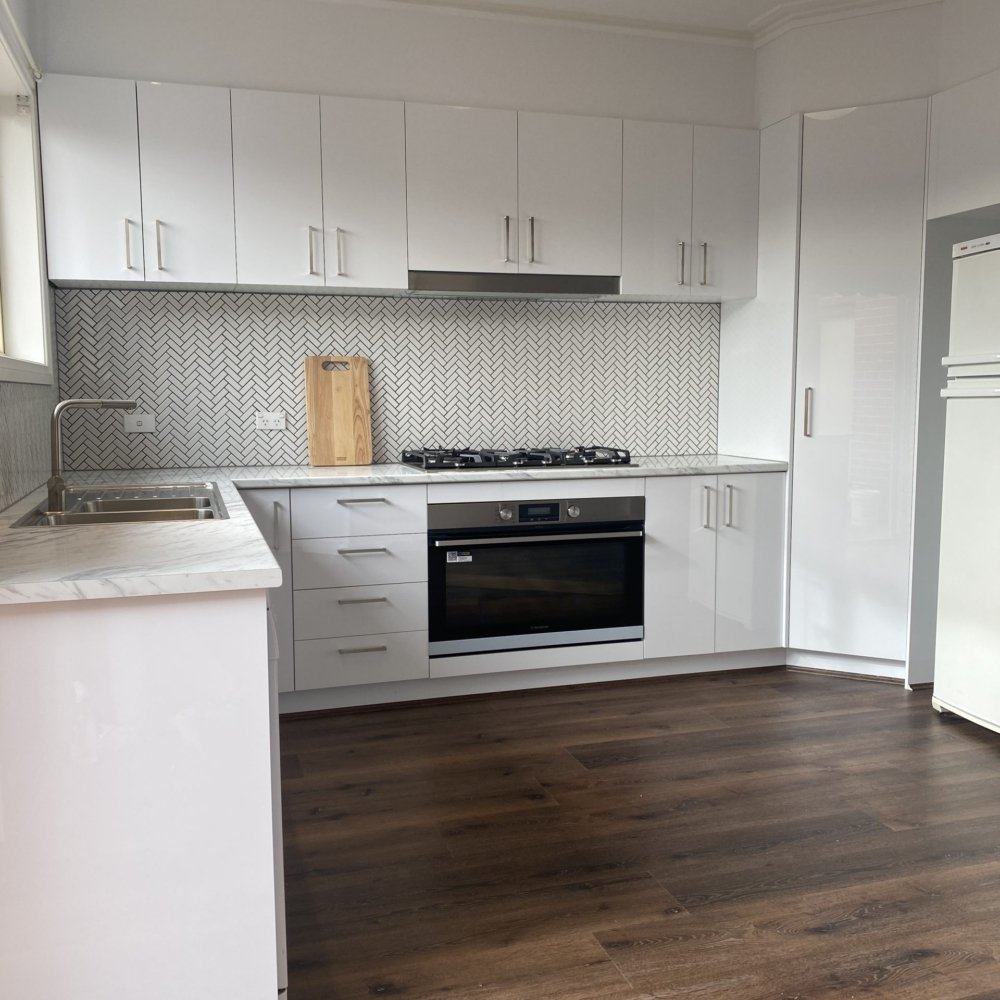 A fully renovated kitchen with modern cabinets and stainless steel appliances
