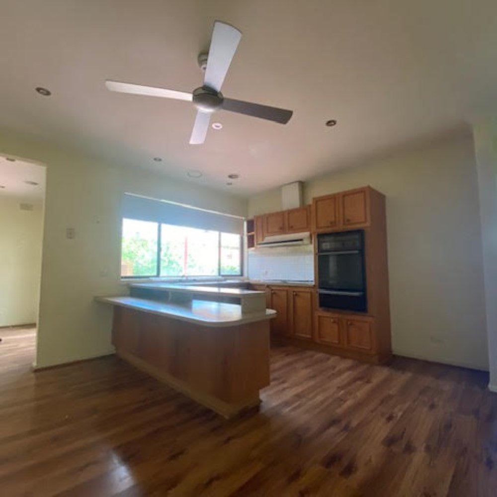 Before image of an outdated kitchen with old cabinets and appliances