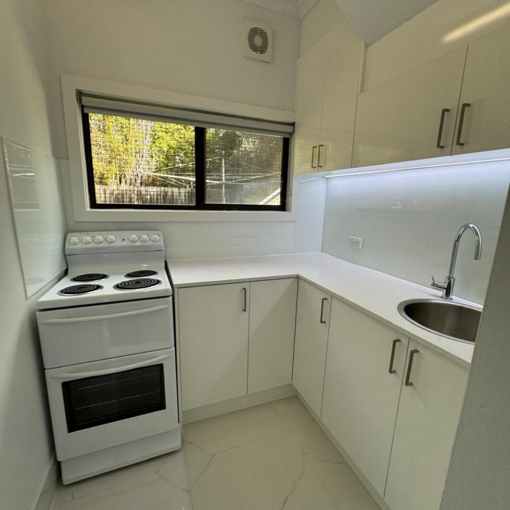 A bright, modern kitchen with updated cabinets, countertops, and appliances after renovation.